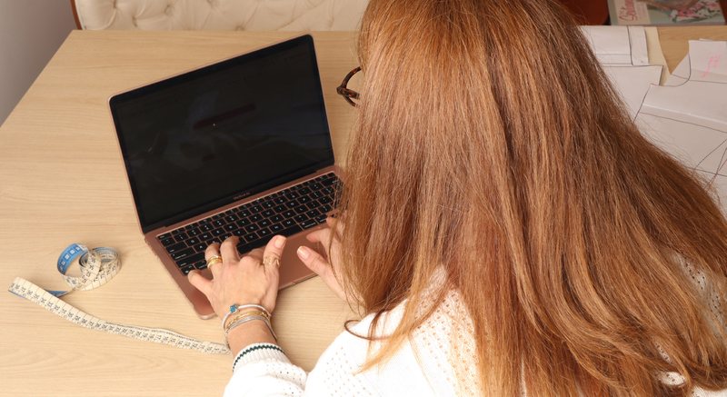 Costureira no computador definindo a folga de vestibilidade antes de gerar o molde