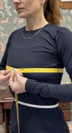 Fita métrica reta e alinhada ao corpo, sem apertar nem folgar